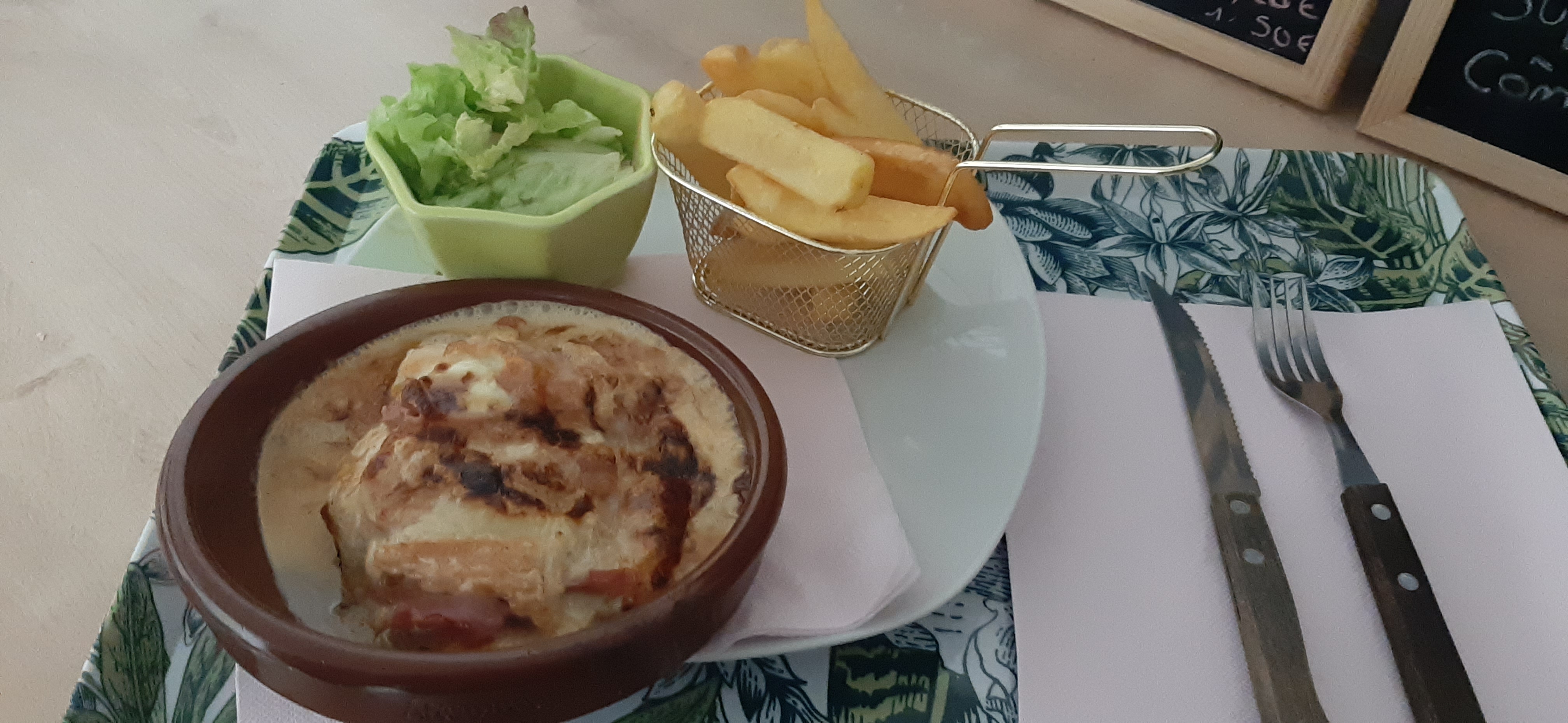 Photo de l'assiette contenant une salade une paniette de frites et un plat contenant une Escalope de poulet à l'Epoisse gratinée